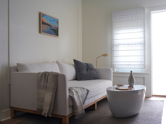 Couch with a modern Snow Day High Gloss Lacquer Finish side table in front of it 