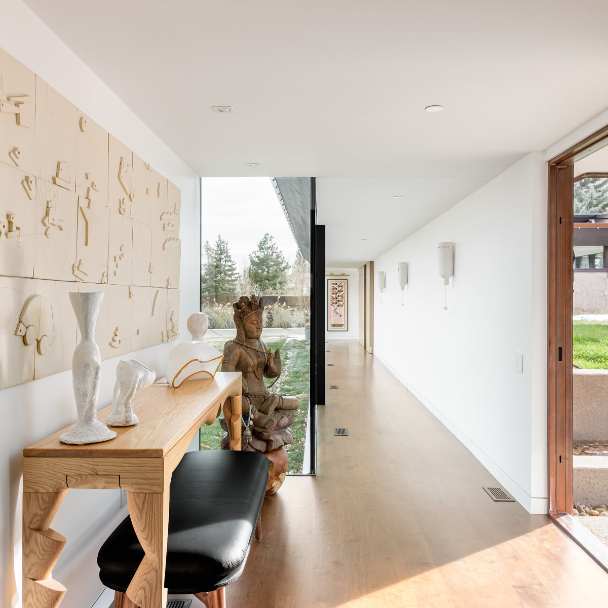 Modern interior with a desk, chair, and decorative items in a bright room.
