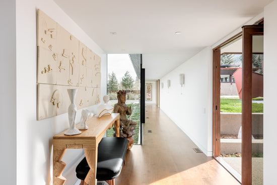 Modern interior with a desk, chair, and decorative items in a bright room.
