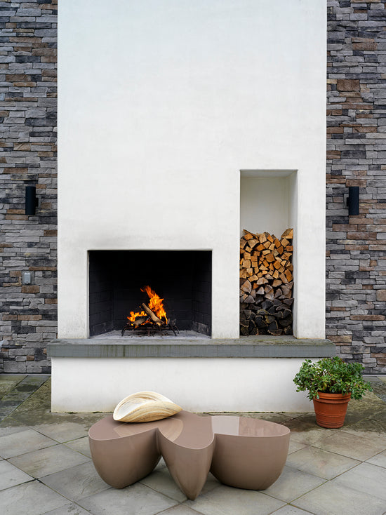 Outdoor fireplace with fire lit, wooden logs stored, and Brown High Gloss Lacquer Finish Outdoor Sizzle 3 
