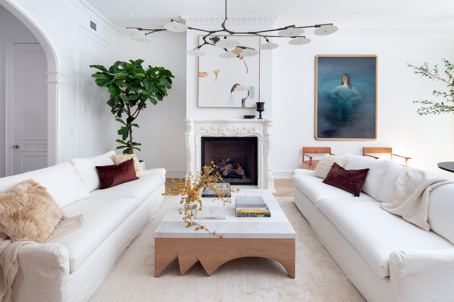Modern living room with white sofas, a Modern white oak table, and decorative elements.
