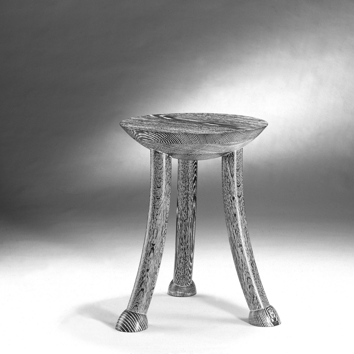 Wooden stool with a textured surface on a neutral background
